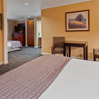 Best Western Plus Humboldt Bay Inn | Eureka, California | King bed with mounted TV beside side table and chair
