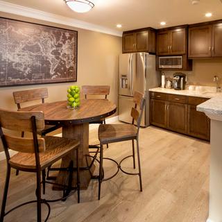 Best Western Plus Humboldt Bay Inn | Eureka, California | Kitchen with brown cabinets, full fridge, and table and chairs